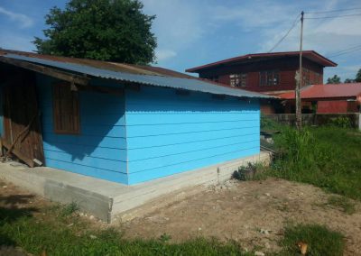 small blue wooden home with cement floor and secure doors