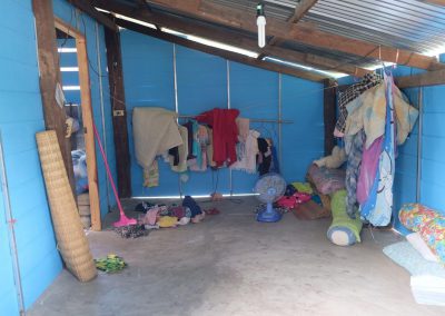 new wooden walls of a home with handing clothes and cement floor