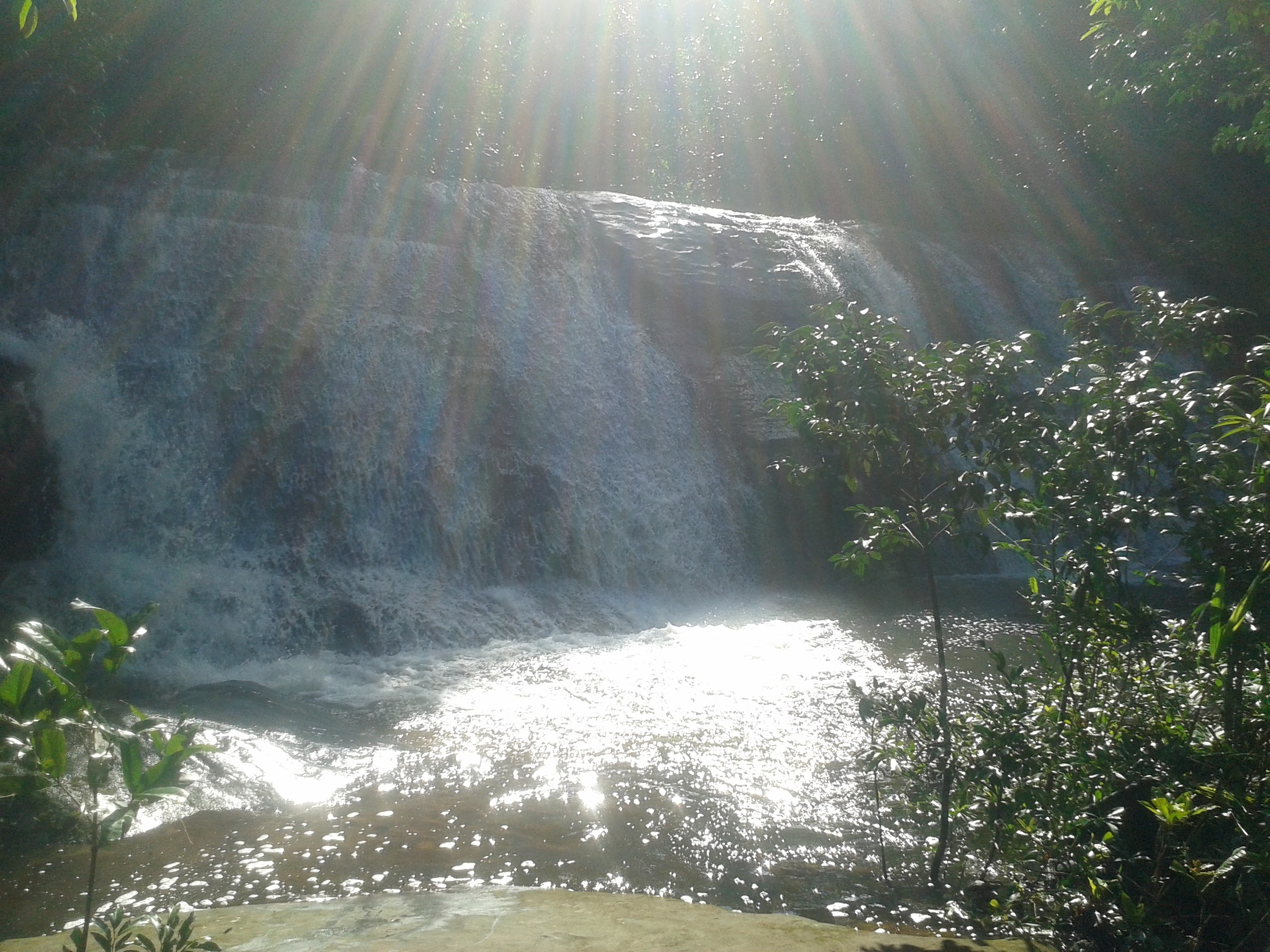 sun shining down on waterfall