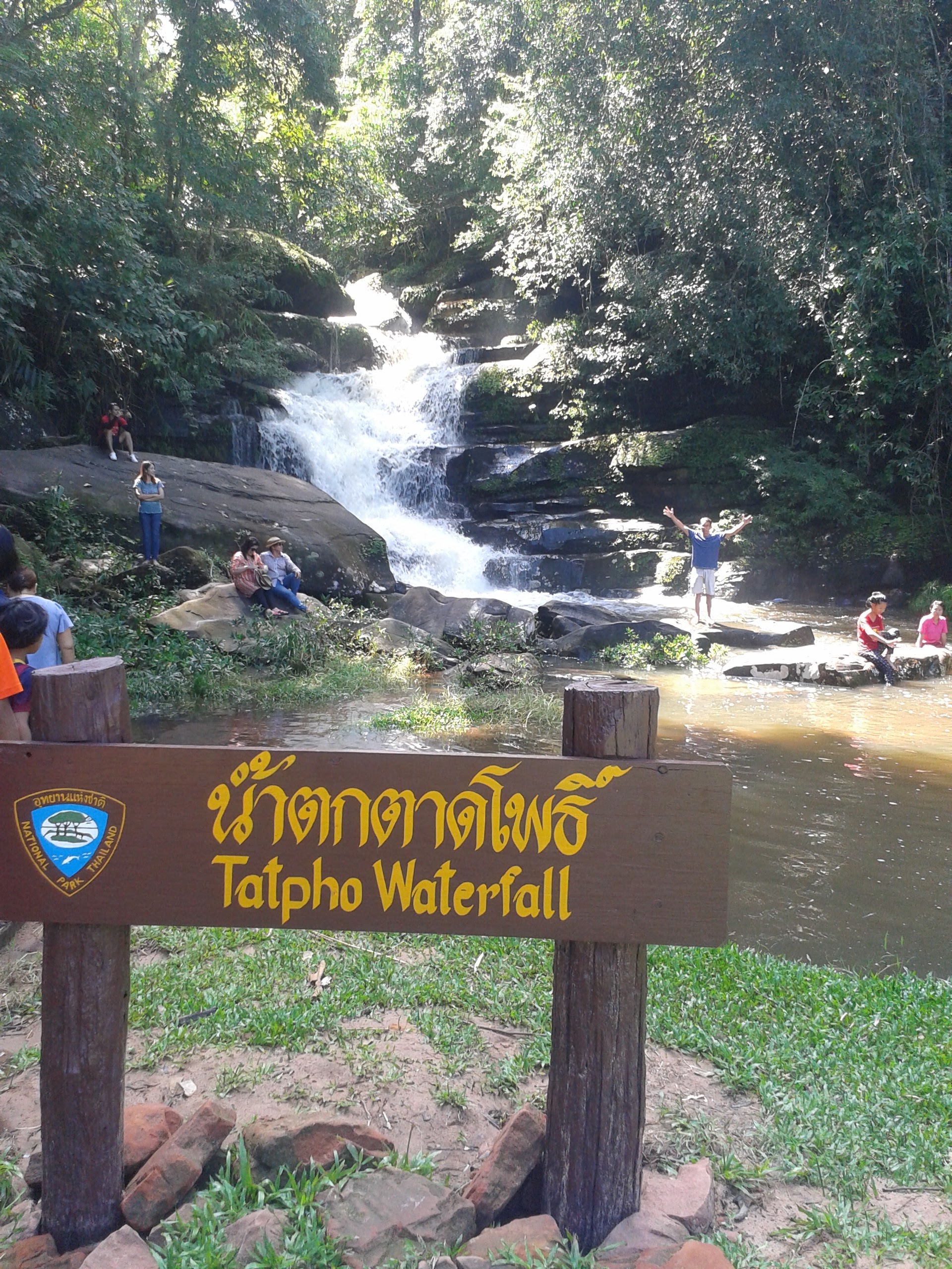sign in english and thai "tatpho waterfall" and waterfall in background