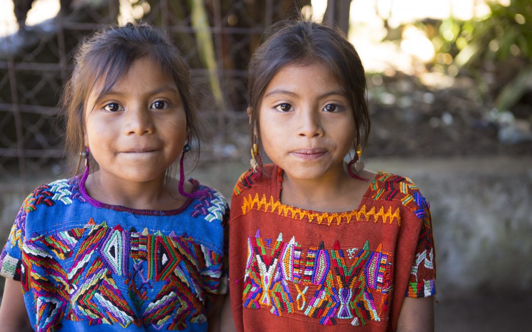 two young Guatemalan girls standing next to each other and smiling