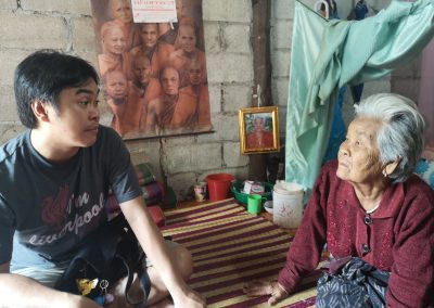 Thai elder Yaai and volunteer Yo sit and talk together