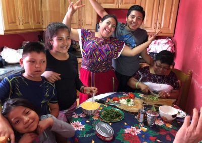 Brandon, one of our scholarship students, in Guatemala with his family in a kitchen