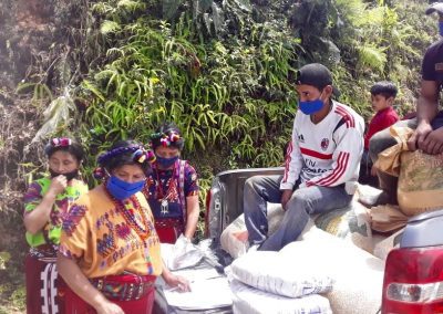 covid care packages Guatemala deliveries group of Guatemalans sitting in the back of a pickup truck with supplies