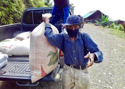 covid rations being delivered in Chajul, man carries a bag of grain out of the back of a truck