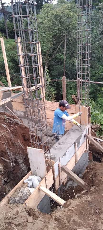 a man works on adding bricks to the foundation of a building, construction just starting