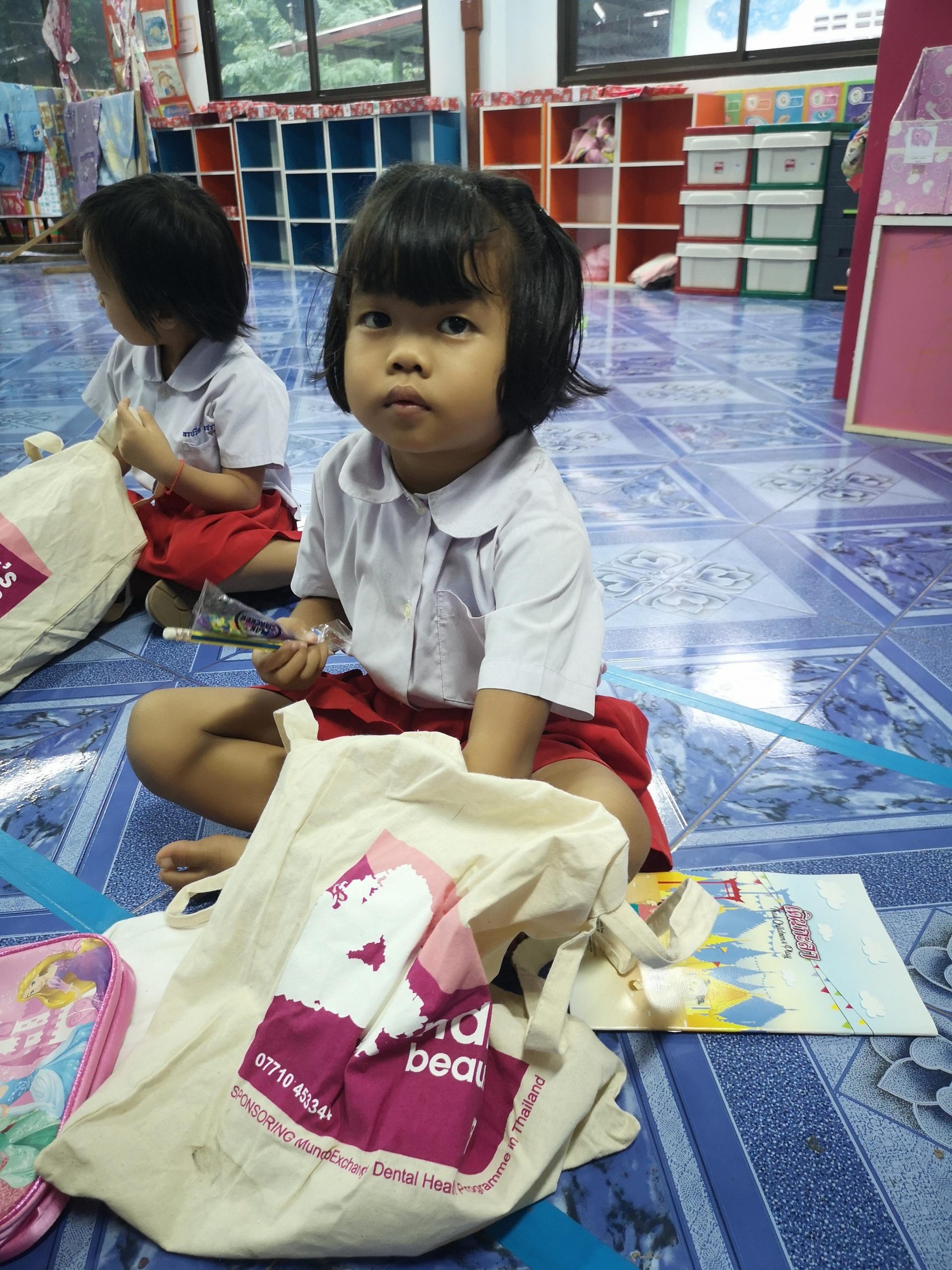 young girl in village school Thailand sitting in the floor