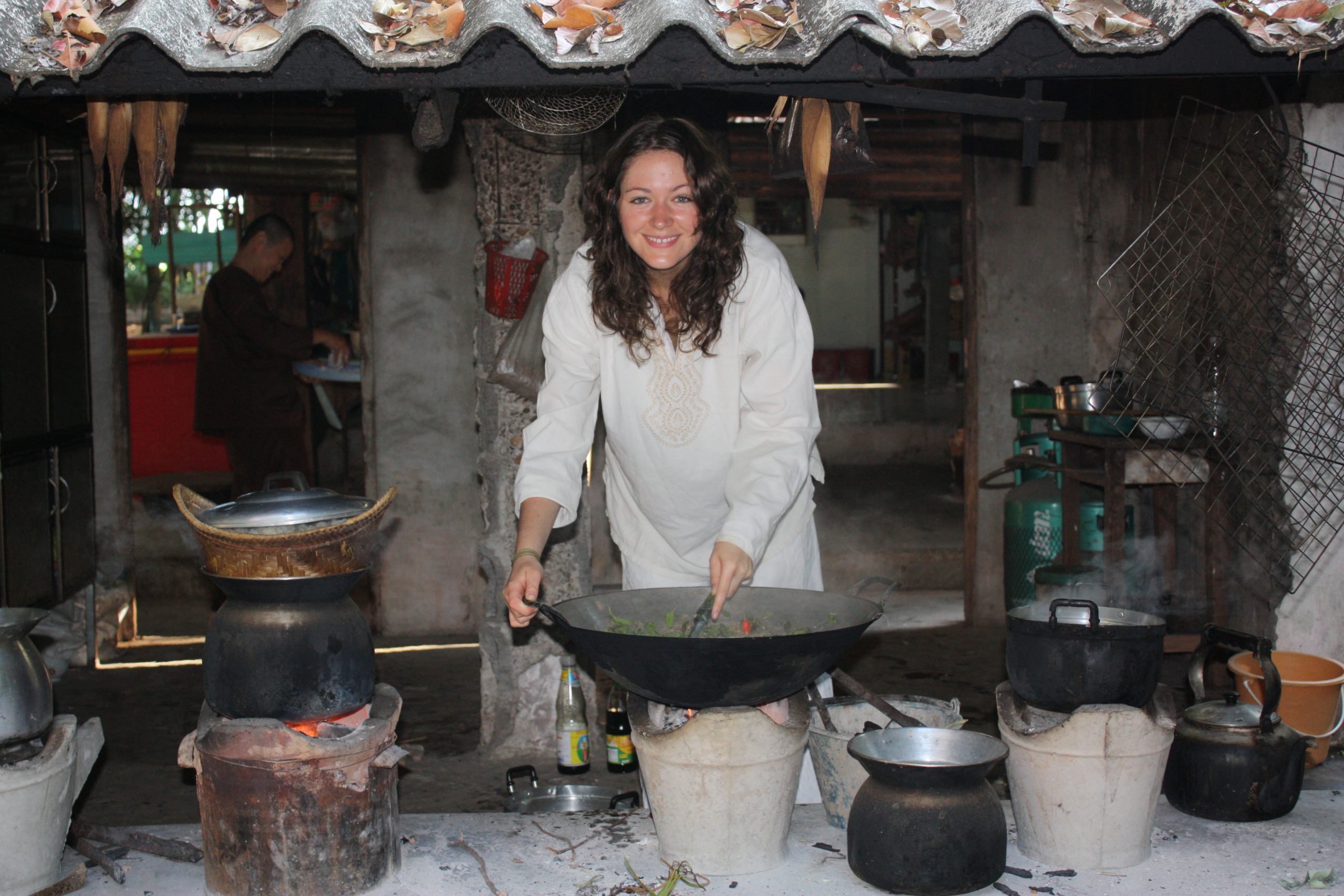 young woman in rural thai kitchen cooking