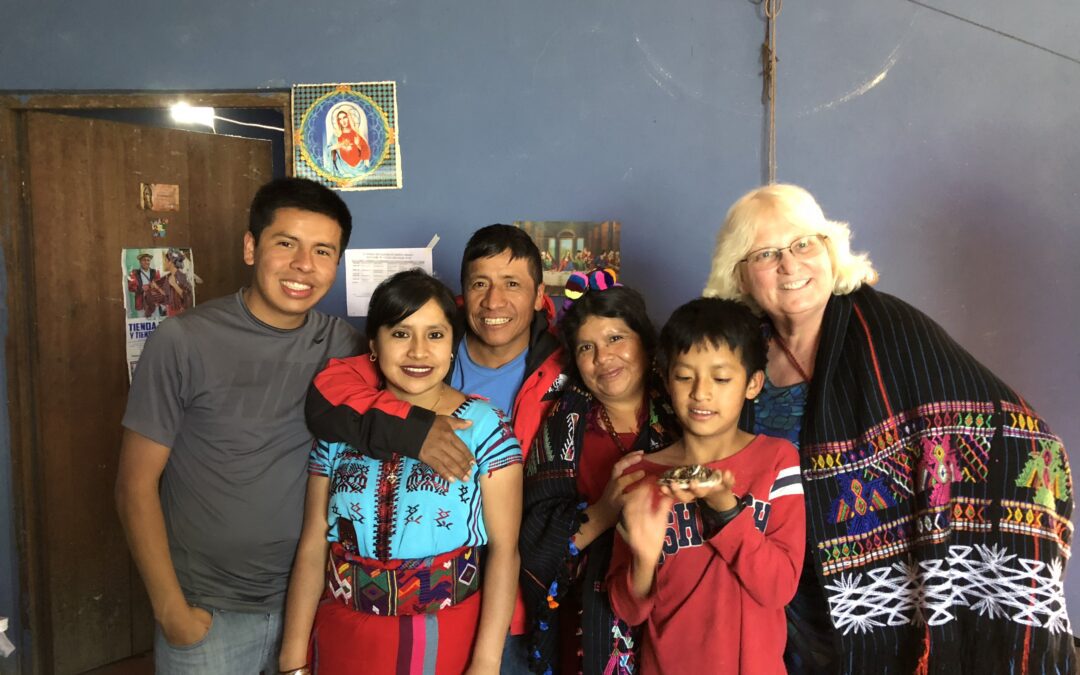 Phyllis stands smiling with a Guatemalan family in their home