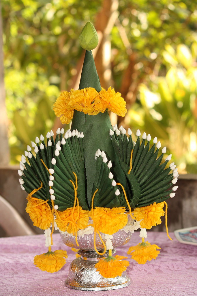 a close up of a bai sri tree, made of banana leaves with detail and adorned with yellow flowers